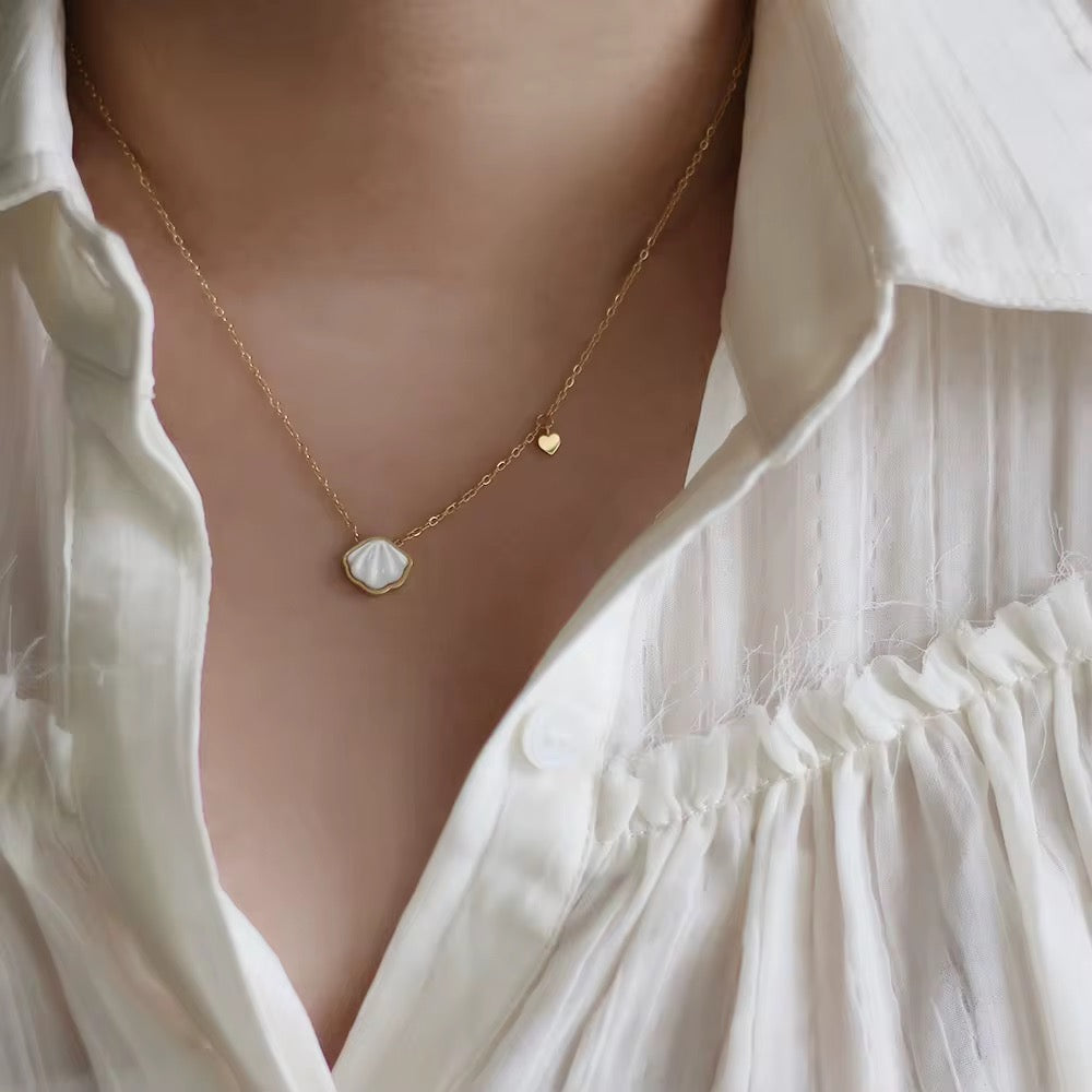 Shell Necklace with a pendant worn by a person in a white outfit