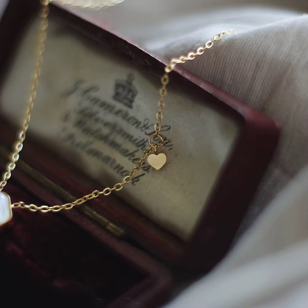 Gold necklace with a heart pendant on an old book