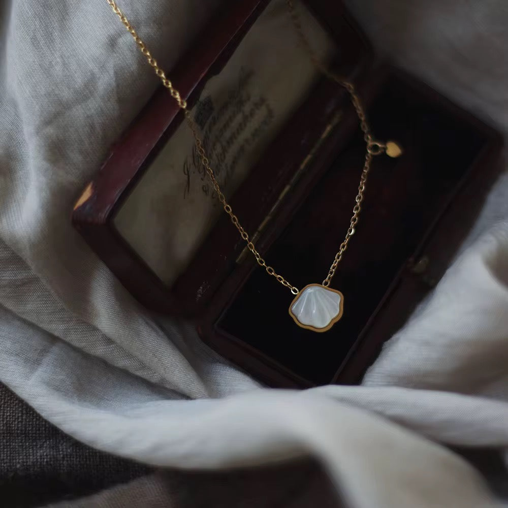 Gold necklace with a pendant on a textured surface