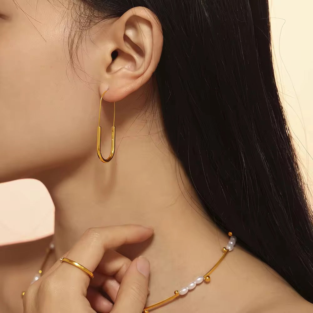 Close-up of a person wearing gold hoop earrings 