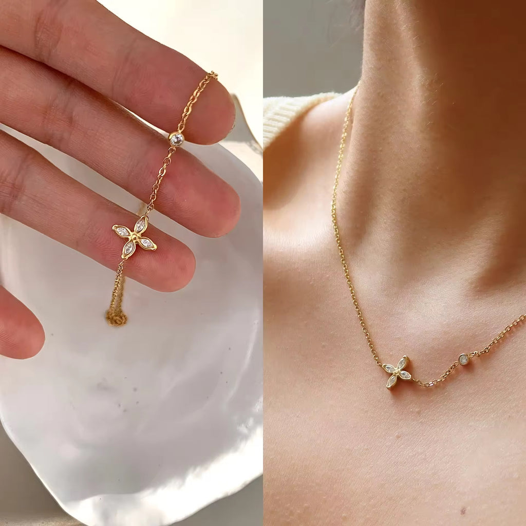 Gold necklace with a butterfly pendant worn on a person's neck.