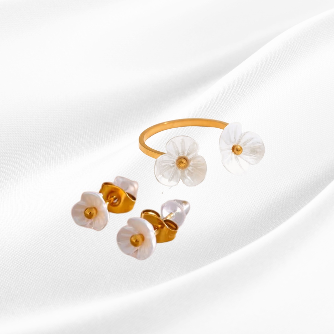 Gold and white floral earrings on a light background