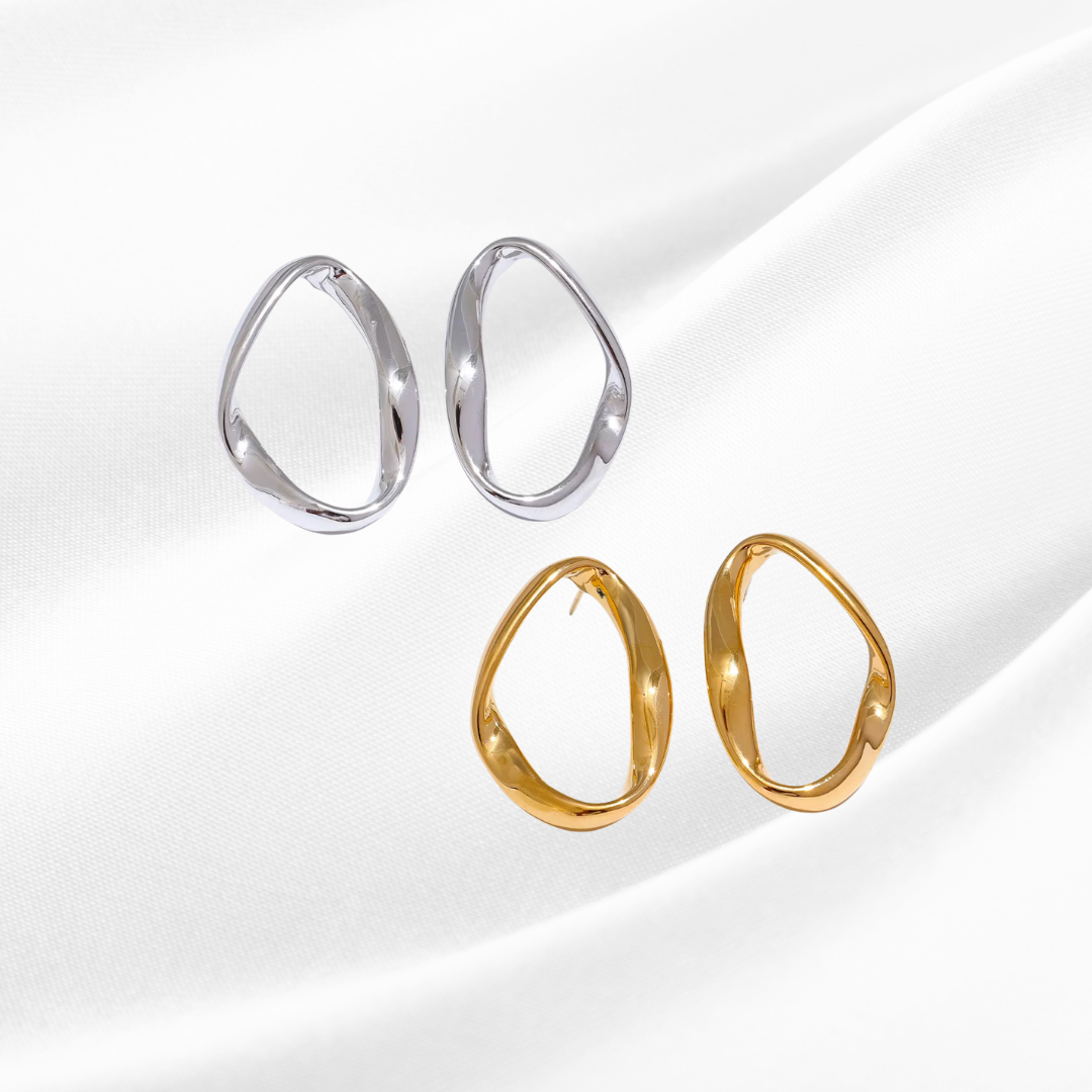 Pair of silver hoop earrings and gold hoop earrings on a white background