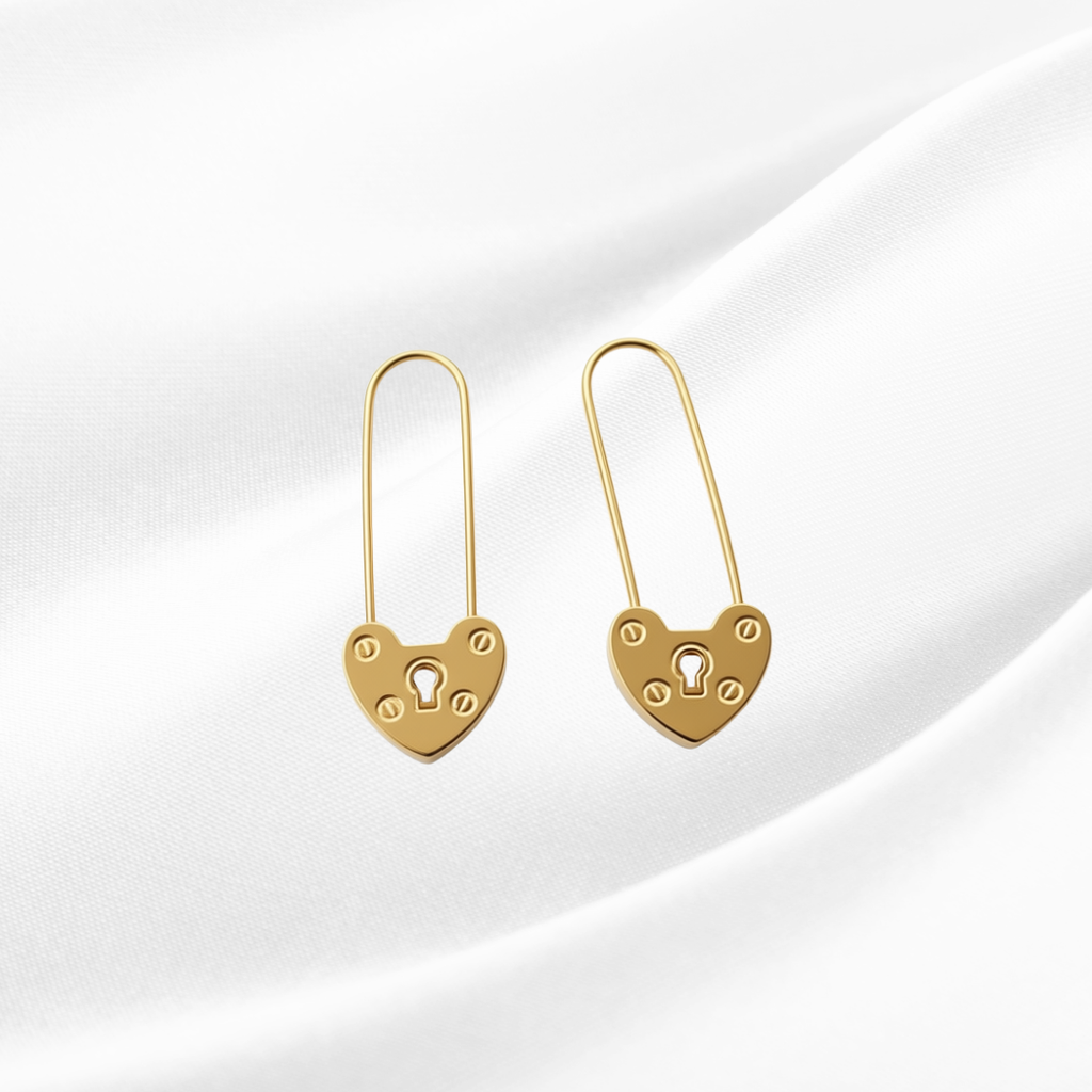 Gold heart-shaped lock earrings on a white background