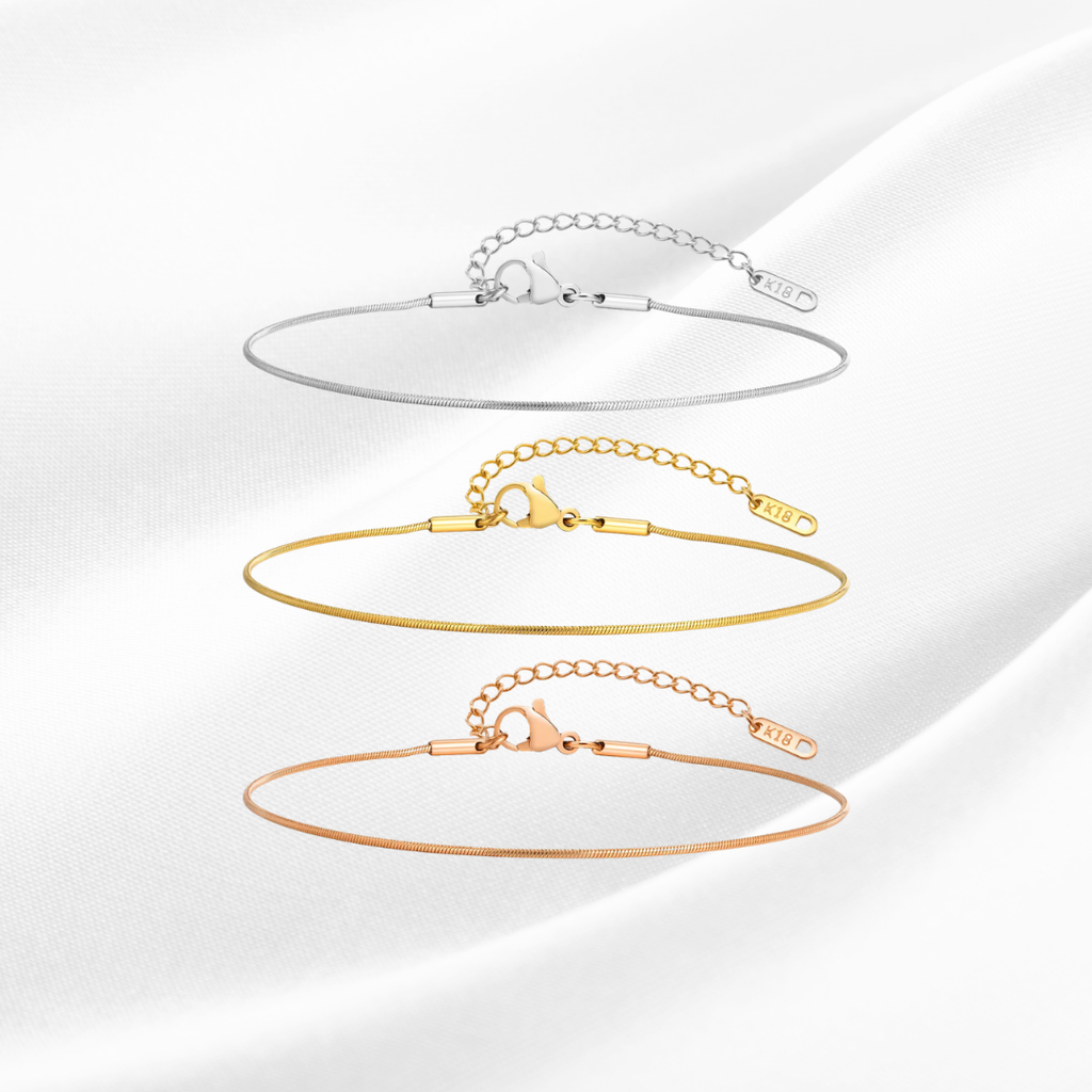 Set of three gold bracelets on a white background