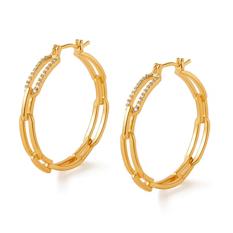 Gold hoop earrings with embedded stones on a white background