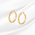Gold hoop earrings with embedded stones on a white background