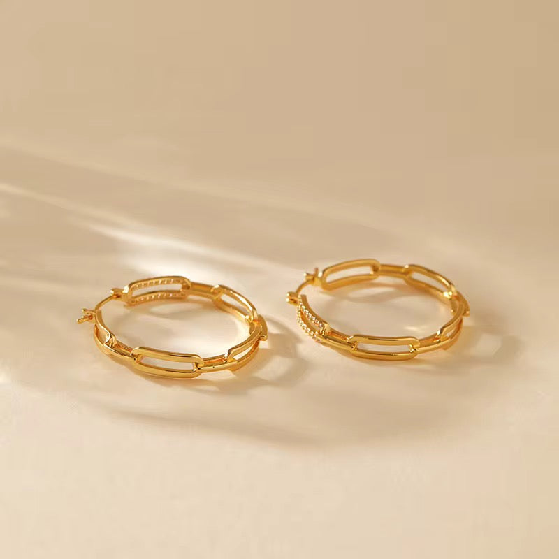Gold hoop earrings on a beige background