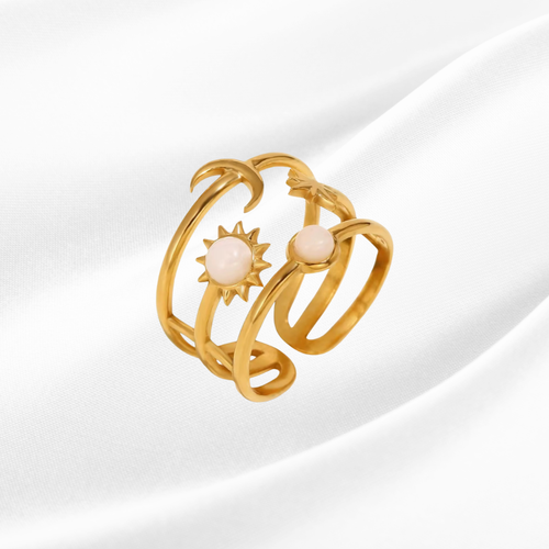 Gold ring with sun and moon designs on a white background