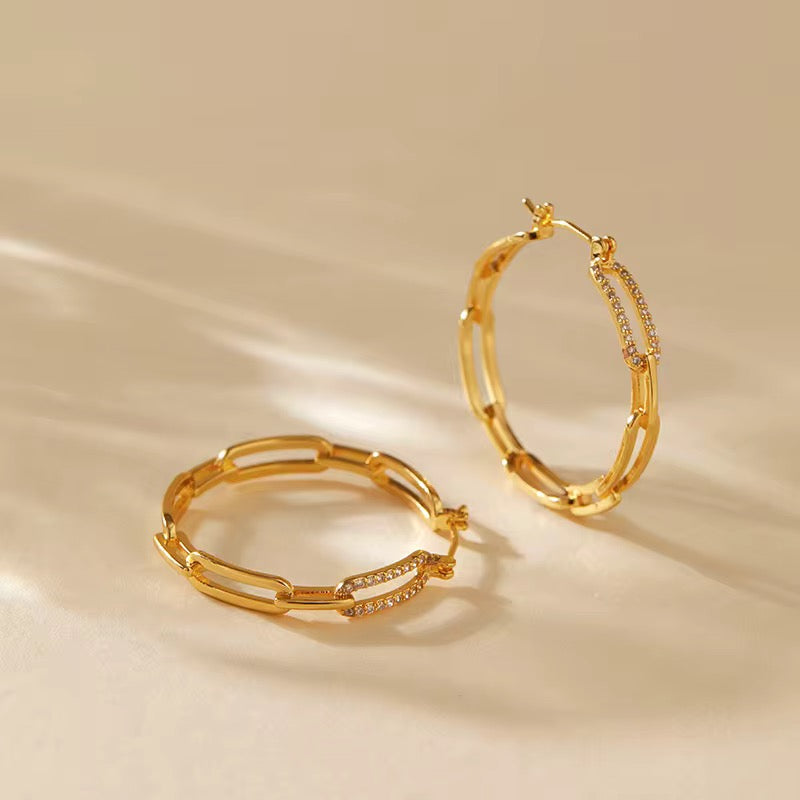 Gold hoop earrings on a beige background