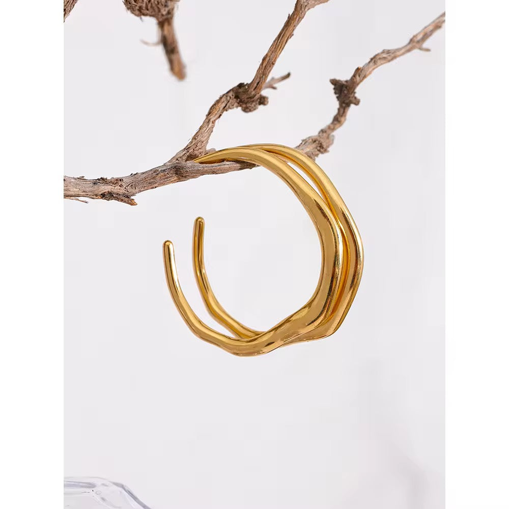 Gold hoop earring on a branch with a white background