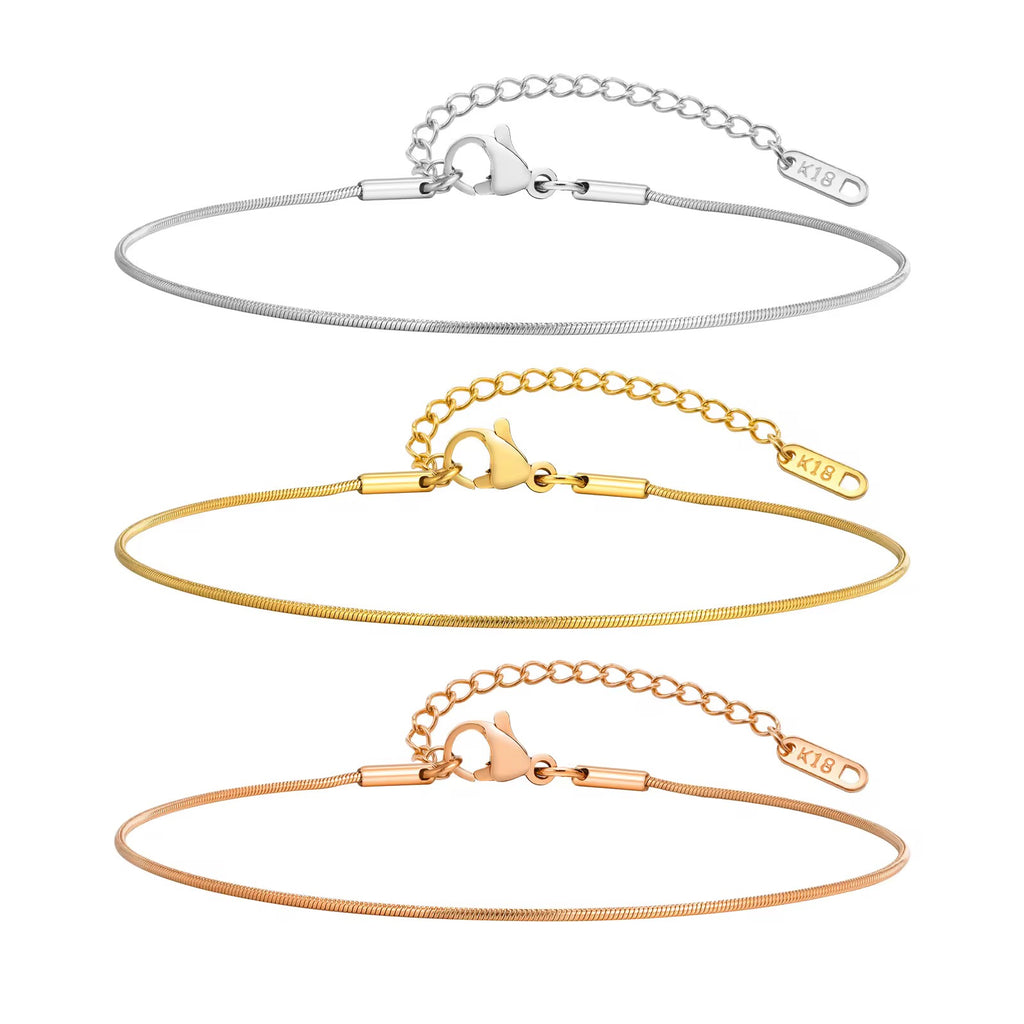 Set of three gold bracelets on a white background