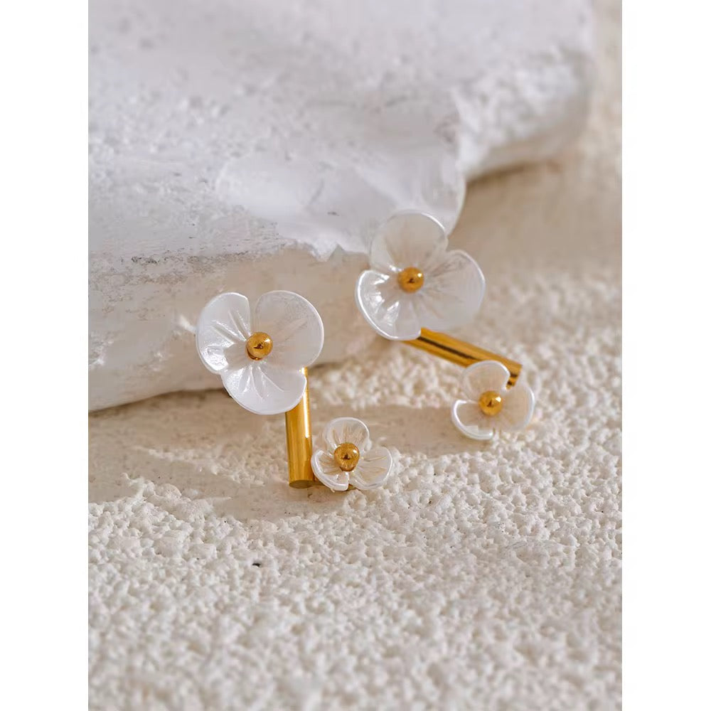Floral hair clip with gold accents on a textured white surface