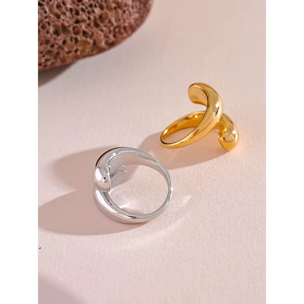 Gold and silver rings on a textured beige surface