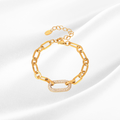 Gold chain bracelet with a heart charm on a white background