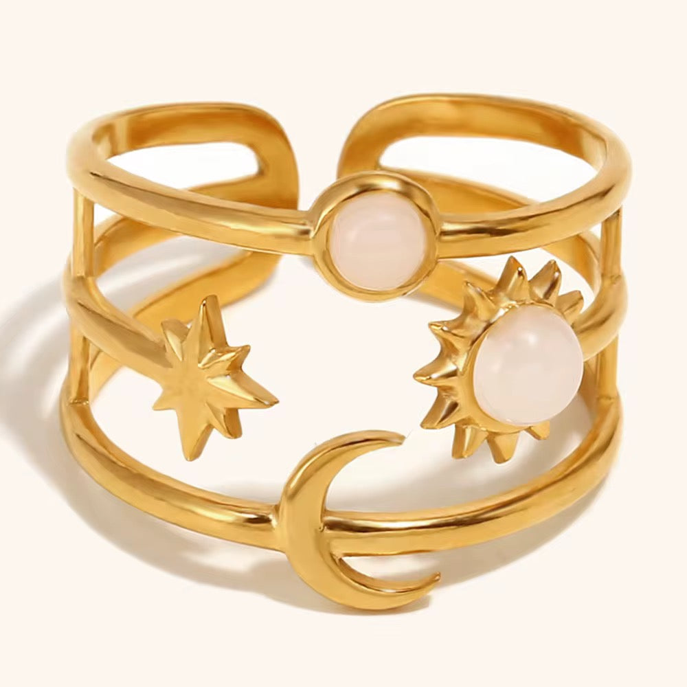 Gold ring with celestial designs on a white background
